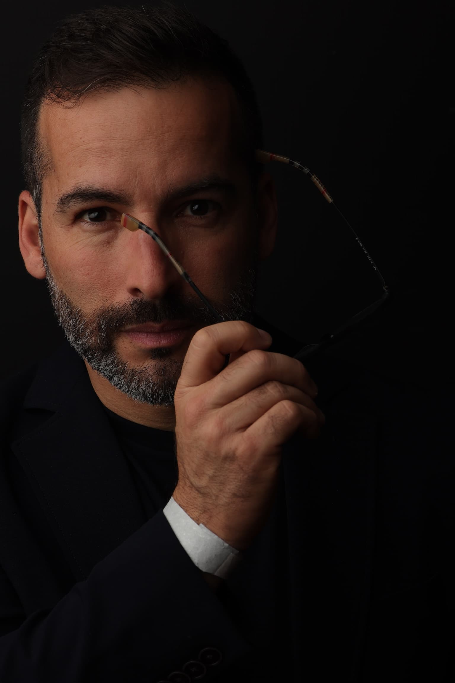 Retrato em preto e branco de Valentim Magalhães segurando óculos